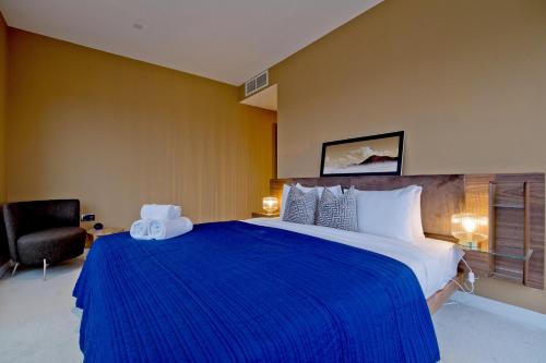 a bedroom with a large bed with a blue blanket at Luxury 360 Penthouse with gym & parking in London
