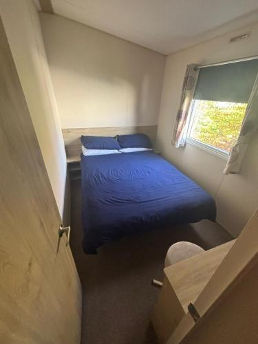 a small room with a bed and a window at Highfield Grange Holiday Park in Little Clacton