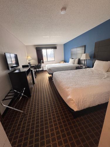 a hotel room with two beds and a flat screen tv at Baymont Inn & Suites Richmond in Richmond