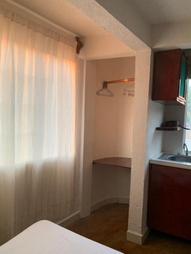 eine Küche mit einem weißen Vorhang und einem Waschbecken in der Unterkunft Habitaciones Nava in Brisas de Zicatela