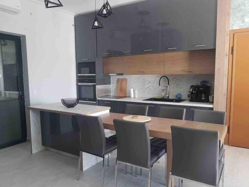 a kitchen with a wooden table and gray chairs at Premium Luxury Condo with breathtaking views in Loutraki