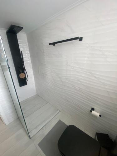 a bathroom with a white wall and a toilet at Premium Luxury Condo with breathtaking views in Loutraki