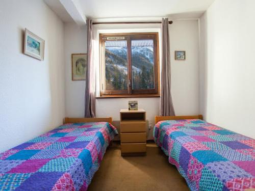 une chambre avec deux lits jumeaux et une fenêtre dans l'établissement Charmant 2 pièces avec parking à Chamonix, animaux acceptés - FR-1-517-19, à Chamonix-Mont-Blanc