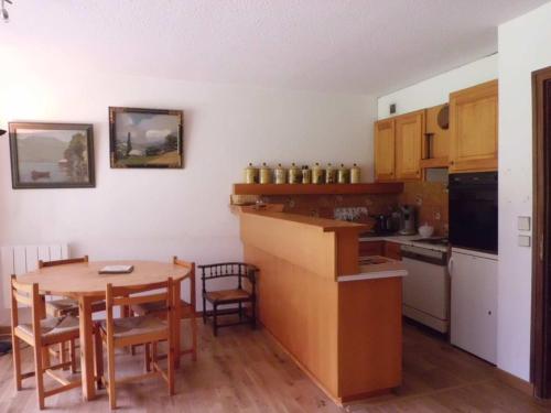 une cuisine avec une table en bois et une table et des chaises dans l'établissement Appartement de 65m² pour 6 pers, terrasse, parking, animaux admis - FR-1-517-38, à Chamonix-Mont-Blanc
