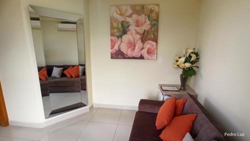 a living room with a couch and a mirror at River Park Hotel in Resende
