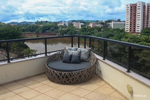 a balcony with a rattan chair with a view at River Park Hotel in Resende