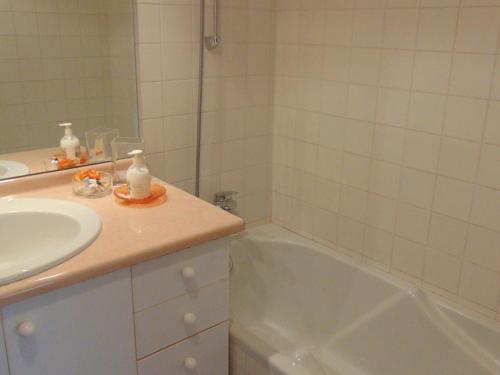 une salle de bain avec un lavabo et une baignoire dans l'établissement Charmant 2 pièces au centre avec terrasse et garage à Chamonix - FR-1-517-41, à Chamonix-Mont-Blanc