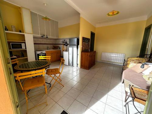 une cuisine et un salon avec une table et des chaises dans l'établissement Appartement pleine nature 2pers - A1, à Grimaud