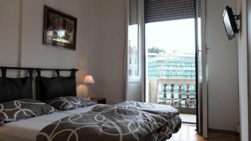 sypialnia z łóżkiem i dużym oknem w obiekcie B&B Piazza Goldoni w Trieście