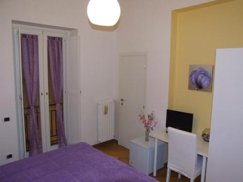 a bedroom with a purple bed and a desk at Bed and Breakfast Adelberga in Salerno