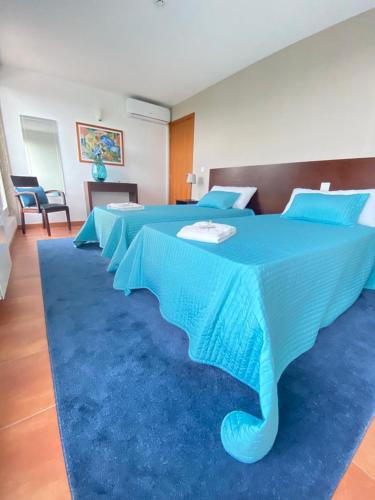a large blue bed with a blue rug in a room at Meiros House Tourism and Nature by Gerês Casas in Amares