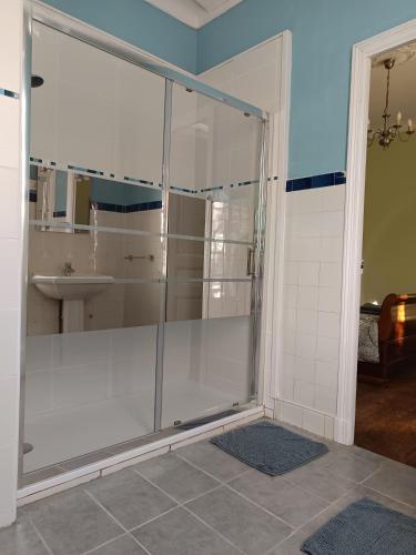 une douche en verre dans une salle de bain avec un lavabo dans l'établissement Maison Vive La Vie, à Couiza