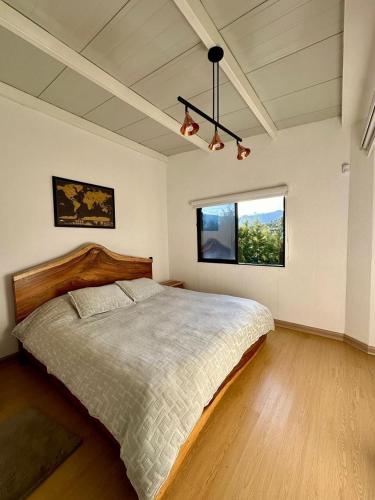a bedroom with a large bed and a window at Finca Amatista in Guarne