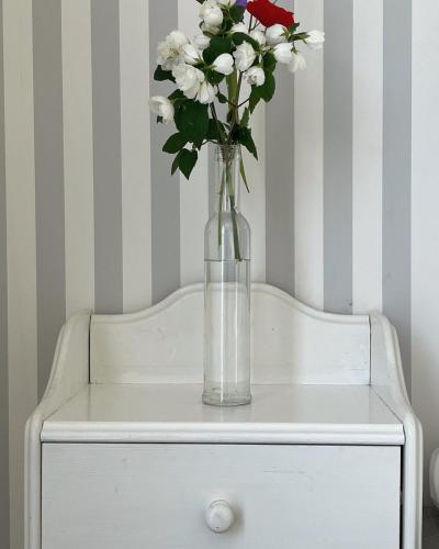 a vase of flowers on top of a white dresser at Liseleje Badehotel in Liseleje