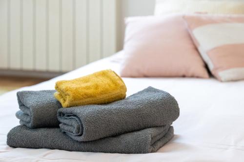 a pile of towels sitting on a bed at Appartamento BellaVeduta in Gorizia