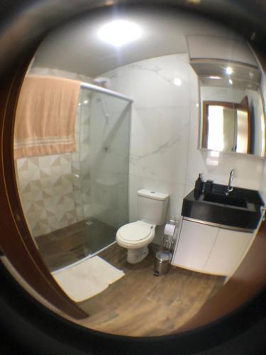 a bathroom with a toilet and a sink and a mirror at Pousada Soares in Piçarras