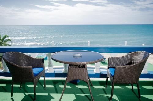 a table and chairs with the ocean in the background at Beyond Sunset Resort & Villas in Treasure Beach