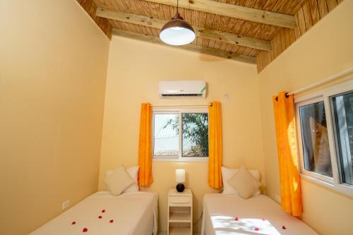 a room with two beds and a window at Beyond Sunset Resort & Villas in Treasure Beach