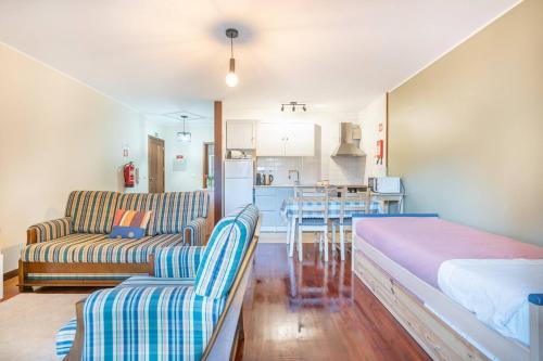 a living room with a couch and a kitchen at Tulipa do Gêres in Geres