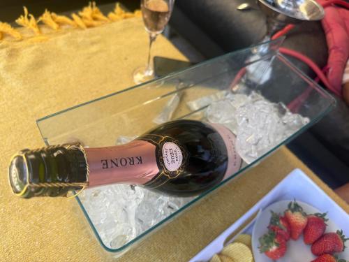 a bottle of wine next to a plate of strawberries at Horizon Bed and Breakfast in Roodepoort