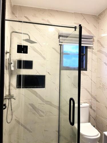 a bathroom with a glass shower with a toilet at Gorgeous 4 Bedrooms Single Family Home at Ibeju, Lekki Lagos in Lekki
