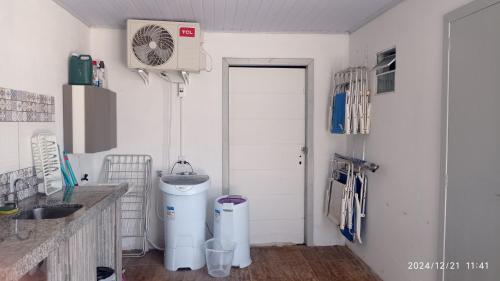 a kitchen with a sink and a fan on the wall at Casa da Praia Capão da Canoa in Capão da Canoa