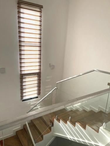 a glass staircase in a white room with a window at Gorgeous 4 Bedrooms Single Family Home at Ibeju, Lekki Lagos in Lekki