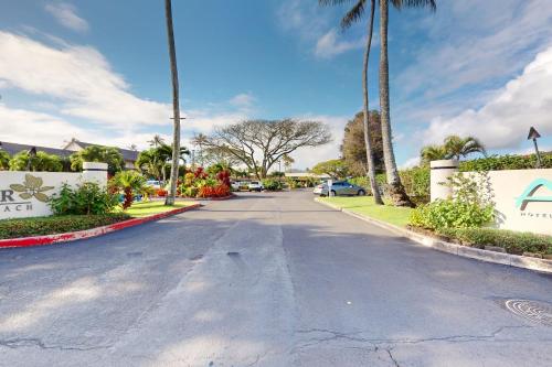 a street with palm trees in a residential neighborhood at Islander on the Beach 211 in Kapaa