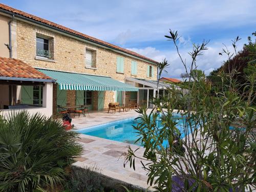 une maison avec une piscine à côté d'un bâtiment dans l'établissement Le clos de fougère, à Cissé
