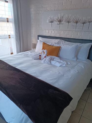a large white bed with a stuffed animal on it at The Berna in Cape Town
