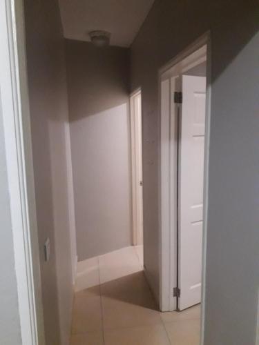 an empty room with a door and a hallway at Claricia's 1 bedroom ,1 bathroom furnished Apt in Friar's Bay