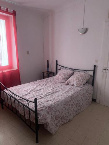 a bedroom with a bed with a white comforter and a window at Gîte climatisé proche lac et Mer avec accès jacuzzi en sus in Vauvert