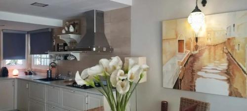 a kitchen with a vase of white flowers on a table at Spacious House in Calafell with Shared Pool in Calafell