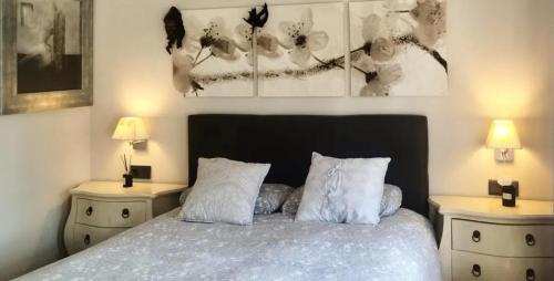 Un dormitorio con una cama con dos mesitas de noche y dos lámparas. en Spacious House in Calafell with Shared Pool, en Calafell