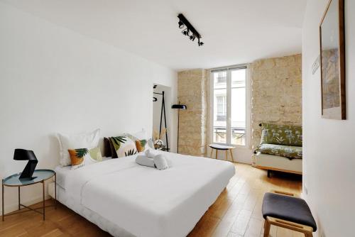 une chambre avec un grand lit blanc et un canapé dans l'établissement LE MARAIS - UPPER CLASS Suites, à Paris