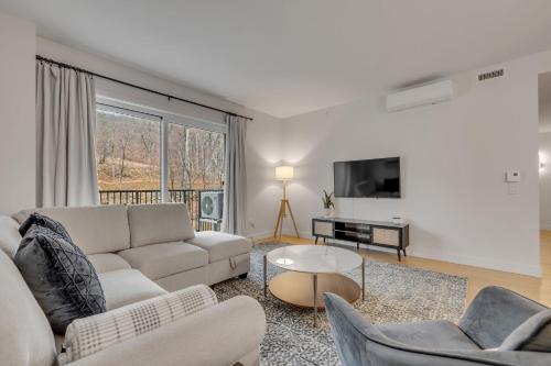 a living room with a couch and a tv at Initial - Mountain 302 - Ski-in-out MSA in Beaupré