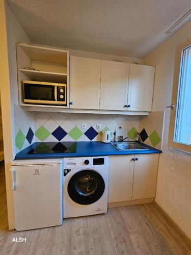 une cuisine avec un lave-linge et un micro-ondes dans l'établissement Appartement 6 Pers à St Raphaël avec piscine, à Saint-Raphaël