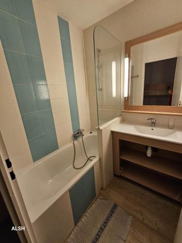 une salle de bain avec une baignoire, un lavabo et un miroir dans l'établissement Appartement 6 Pers à St Raphaël avec piscine, à Saint-Raphaël