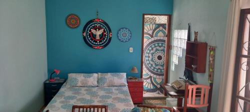 a bedroom with a bed and a blue wall at Chalé Puertas y Ventanas in São Sebastião