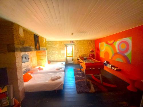 a room with two beds and a desk in it at La Maison Pop-70's-Spot Nature-B&B in Sarrant