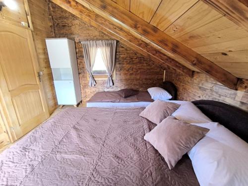 a bedroom with a large bed in a attic at Wooden Lakeside Cottage in Virpazar