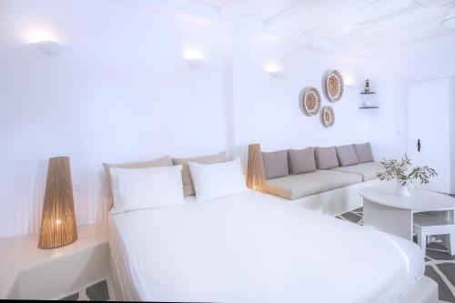 a white bedroom with a large bed and a couch at Penelope Villas in Karistos