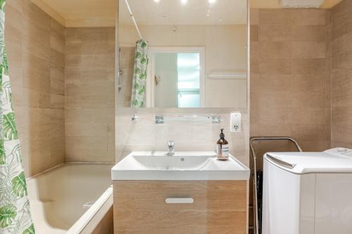 une salle de bain avec un lavabo et une baignoire dans l'établissement Heart of Paris III, Le Marais - Charming Apartment, à Paris