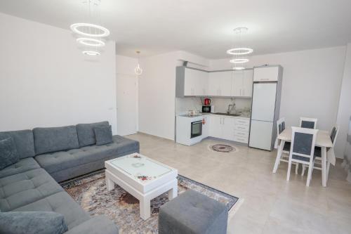 un soggiorno con divano, tavolo e cucina di Nedo Apartament's a Sarandë