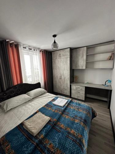 a bedroom with a bed with a blanket and a desk at 1977 GUEST house in Karakol