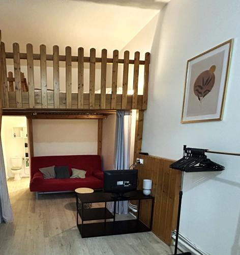 - un salon avec une mezzanine et un canapé rouge dans l'établissement Studio spacieux, centre ville, à Le Pont-de-Beauvoisin