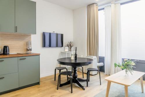 une cuisine et une salle à manger avec une table et des chaises dans l'établissement Enjoy in a Lovely Nest with modern design, à Paris