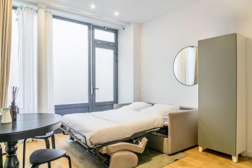 une chambre avec un lit, une table et une fenêtre dans l'établissement Enjoy in a Lovely Nest with modern design, à Paris