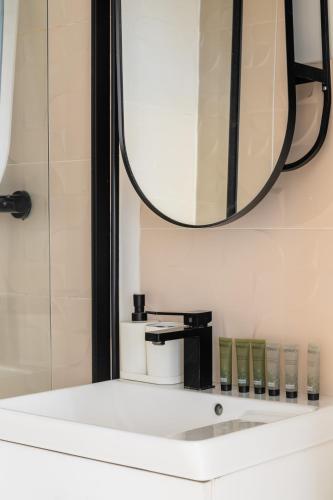 une salle de bain avec un miroir et un lavabo dans l'établissement Enjoy in a Lovely Nest with modern design, à Paris