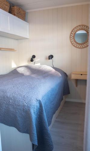 a bedroom with a blue bed with two lights on it at Koselig leilighet med Ski Bike in and out Nr 34 in Hafjell